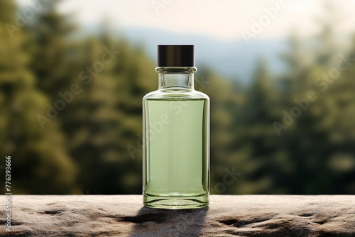 Glass bottle with green liquid on blurred background with pine trees. 