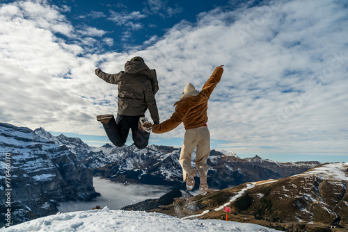 Couple jumping in the air on the background of the alps, Interlaken, Switzerland. 01-Jan-2024