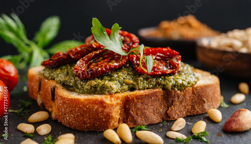 Close-up of toasted bread with vegan pesto spread with sun-dried tomatoes and pine nuts. Tasty food.