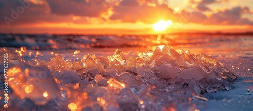 The sun is setting over the ocean, casting a warm glow on the icy beach. Ice crystals sparkle as the tide recedes, creating a beautiful contrast between the frozen shoreline and the setting sun.