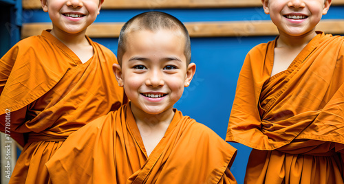 Three young monks standing in a row, smiling and looking at the camera.