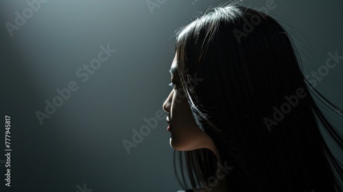 Asian woman with straight black hair side view.