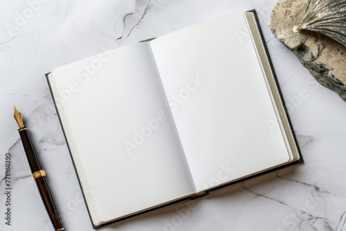 Mockup of an open classic hardcover notebook with a fountain pen on marble surface