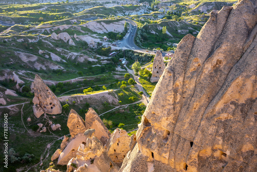 Sunset light bathing Cappadocia's unique rock formations and winding roads in a warm glow
