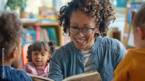 Smiling teacher reading a book to attentive young children