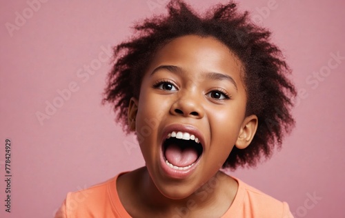 A girl bares her teeth, eyes wide open, against a pink background