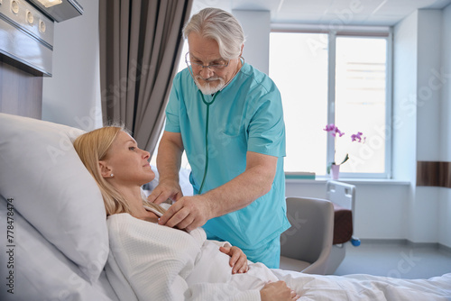 Physician conducting cardiac auscultation of hospitalized patient