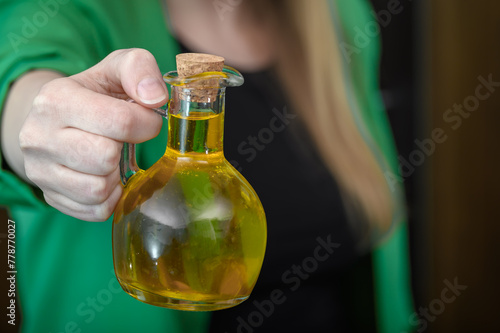 Kobieta pokazuje butelkę włoskiej oliwy z oliwek 