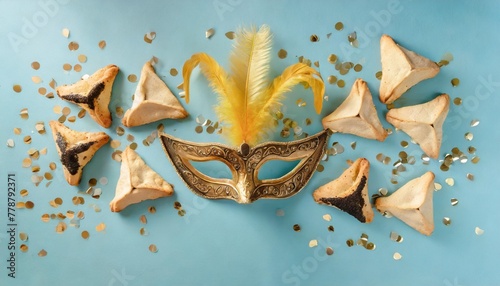 jewish holiday purim creative concept with carnival mask and hamantaschen cookies on blue background top view flat lay composition