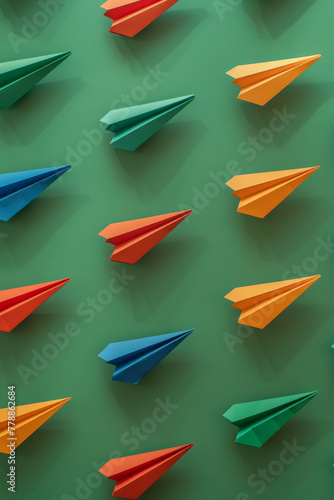 Colorful Paper Airplanes on Green Background - Creative Concept