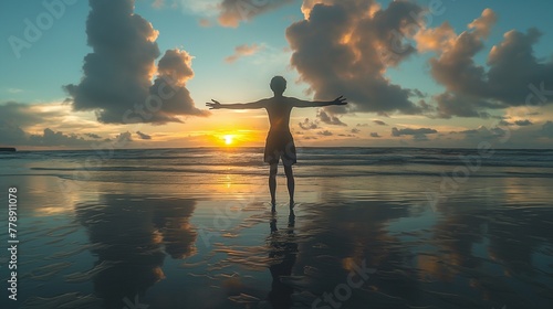 A man stands with his arms outstretched on the beach sunset, silhouette style