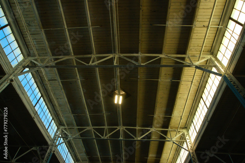 Vast ceiling of a massive industrial warehouse illuminated by rows of transom windows
