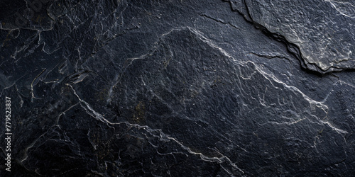 A black rock with a rough texture. The rock is large and has a jagged edge. The image has a moody and mysterious feel to it