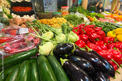 Stragan na bazarze z warzywami. Nowalijki wiosenne. Handel na bazarze. Ogórki, pomidory, rzodkiewki, papryka, fasola, kabaczki, cukinia. 