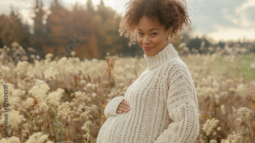 Pregnant woman in knitted sweater holding belly