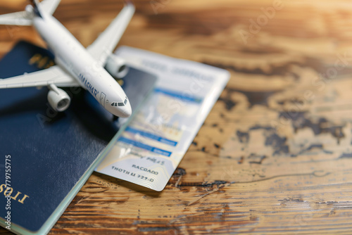 Toy airplane on top of a passport and flight booking ticket