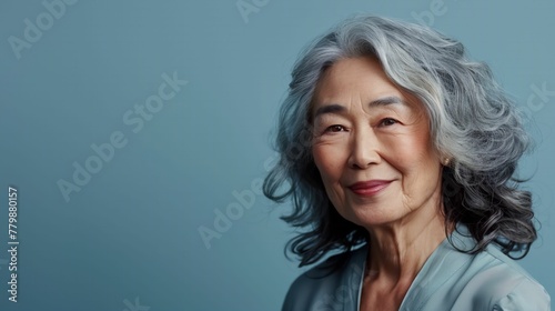 Confident Asian senior woman smiling on background banner. Active and healthy aging with a beautiful Asian woman.