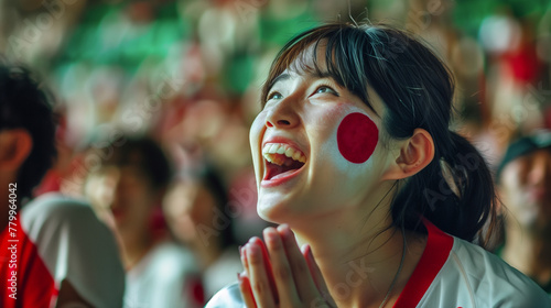 female Japanese woman soccer fan screaming goal in the stands rising hands as victory, japan flag on her face and t-shirt