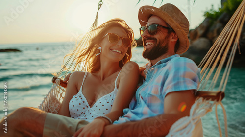 Happy couple relaxing at hammock between palm trees on an idyllic tropical beach, beautiful ocean view. Exotic travel mood, summer vacation background concept.