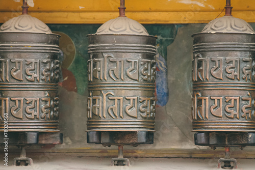 Tibetan prayer wheels with mantras embossed in it and representing spiritual practices in the Buddhism faith in Swayambunath Temple. Kathmandu, Nepal