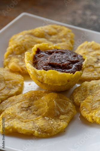 Una exquisita combinación de plátanos verdes fritos y frijoles sazonados, representativos de la cocina caribeña.