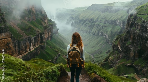A woman is hiking up a mountain with a backpack