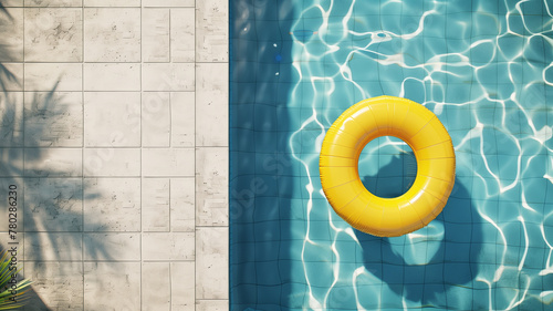 The top view captures a swimming pool under the caress of the sun, with a yellow swim ring afloat, an inviting symbol of summer relaxation and fun.