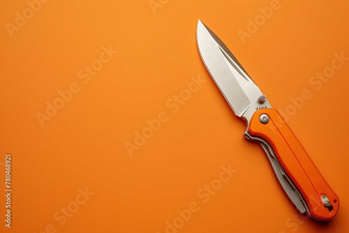 Utility knife on orange background 