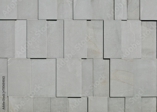 External wall made of horizontal gray granite tiles assembled vertically in relief. Abstract, background and texture.