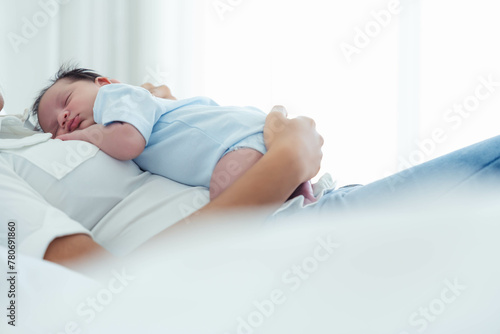 Asian beautiful mom motherhood lie down nursing newborn baby infant toddler, gently hold together on chest with love, infant sleep comfortable with safe and protection by mother taking care on bed 