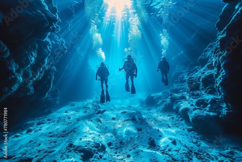Two scuba divers exploring a deep underwater canyon with sunlight streaming from above highlight the vastness and mystery of the ocean depths