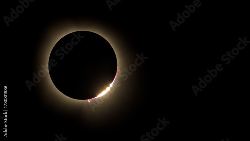 Awe-inspiring color photo of the 2024 solar eclipse showing diamond ring effect and solar prominence with red plasma shooting from the sun's surface. Photo taken from Carbondale Illinois area.