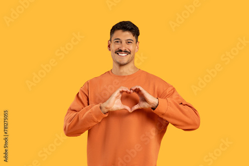 Man with moustache making heart shape with hands