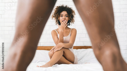 Woman in disbelief looking what's between man's legs