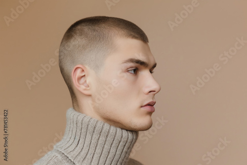 Clean and modern portrait of a young man with a stylish buzz cut, gazing into the distance