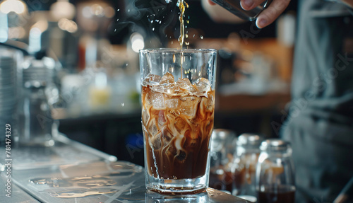 Person pouring drink into glass, iced coffee