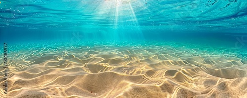 Clear underwater seascape with sunbeams illuminating sand ripples on the ocean floor