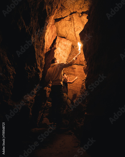 Exploradores en una cueva con una antorcha 