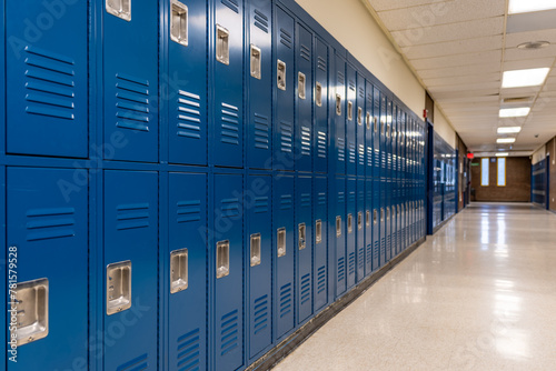 Empty school hallway with blue metal student lockers 