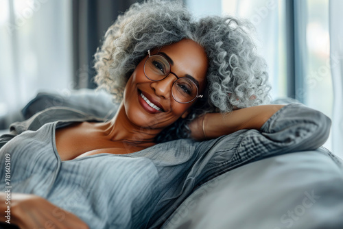 Close up satisfied calm african woman put hands behind head resting daydreaming on sofa, black attractive 60s female spend time at home closed eyes relaxing feels serenity no stress enjoy lazy weekend