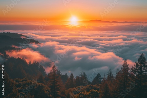 Sun sets behind clouds in mountainous landscape, painting sky with afterglow