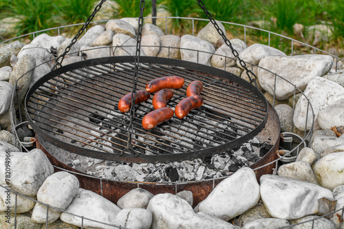 Rakotwórcza niezdrowa przypalona kiełbasa leży na rozgrzanym grillu