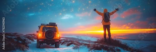 happy male traveler standing next to SUV next sea in nature on winter expedition