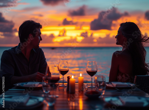 A couple sitting at the table at sunset with candles