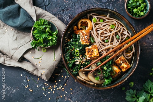 Vegan soba noodle bowl with tofu mushrooms kale sesame seeds and chives Overhead view