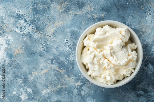 Italian dessert tiramisu ingredient mascarpone cheese cream cheese ricotta in white ceramic bowl Creamy with blue concrete background Top view with copy space