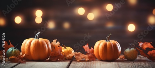 Mini pumpkins and leaves on wooden table with background lights