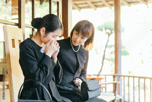 お葬式で泣く喪服を着た遺族の日本人女性 