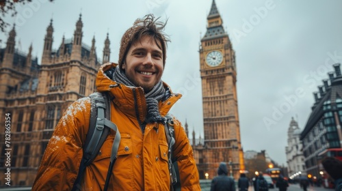 Cheerful tourist captures a selfie moment in front of the iconic snow-covered Big Ben during a wintry day in London.