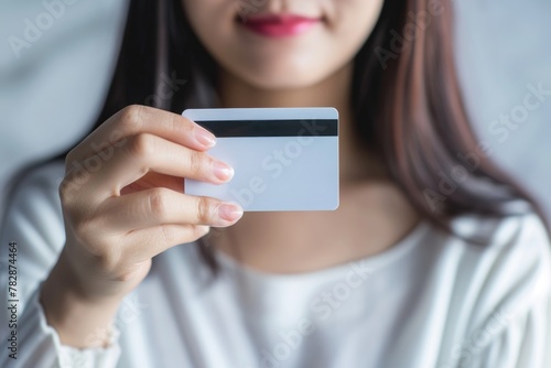 A young woman holding a credit card in her hand and suggesting that she may be shopping or socializing. Fictional Character Created by Generative AI.